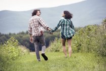 Homme et femme courant dans une prairie — Photo de stock