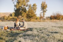 Uomo e donna che fanno un picnic invernale — Foto stock