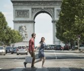 Couple walking by Triumphal Arch — Stock Photo