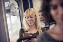 Жінка в автобусі дивиться на мобільний телефон — стокове фото
