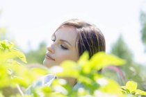 Frau von grünen Pflanzen umgeben — Stockfoto