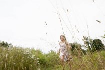 Girl playing in the long grass — Stock Photo