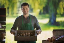 Man with a box of freshly picked fruit. — Stock Photo