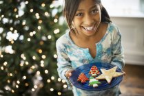 Girl holding plate with Christmas cookies — Stock Photo