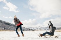Girl pulling her brother on a sledge — Stock Photo
