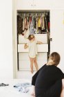 Girl looking for clothes in a chest of drawers — Stock Photo