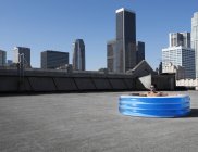 Людина в надувному басейні на даху — стокове фото