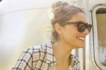 Woman wearing sunglasses by trailer — Stock Photo
