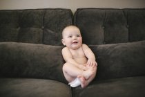 Bambino seduto su un divano — Foto stock