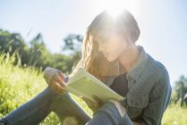 Woman  reading a book on meadow — Stock Photo