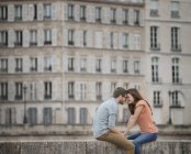 Couple sitting on the bridge over the River Seine. — Stock Photo