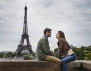 Pareja en París con la torre Eiffel al fondo . - foto de stock