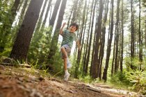 Garçon jouant dans la forêt de pins — Photo de stock