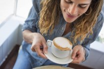 Femme tenant une tasse acoffee au café — Photo de stock