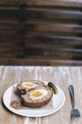 Huevo escocés cortado por la mitad con guarniciones . - foto de stock
