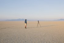 Man with camera and tripod — Stock Photo