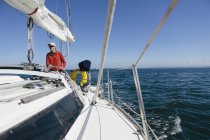 Mann mittleren Alters steuert Segelboot — Stockfoto