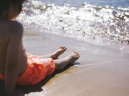 Хлопчик сидить на піску — стокове фото