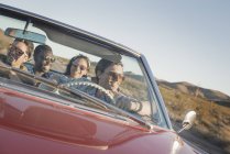 Friends in a red car on a road trip. — Stock Photo