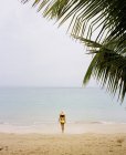 Femme portant un bikini jaune sur une plage — Photo de stock