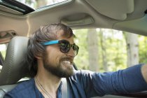 Hombre en gafas de sol en el asiento de conducción - foto de stock