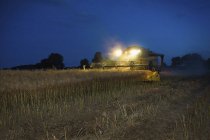 Combine harvester with headlights — Stock Photo
