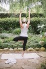Donna che fa yoga in un giardino
. — Foto stock