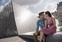 Couple in the courtyard of the Louvre museum — Stock Photo