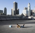 Homme couché sur le ventre sur un toit de la ville — Photo de stock
