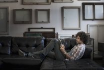 Mann auf Sofa mit digitalem Tablet. — Stockfoto