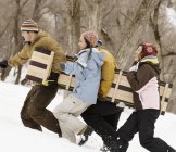 Pessoas carregando um trenó de madeira — Fotografia de Stock