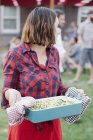 Femme portant un grand plat de légumes — Photo de stock