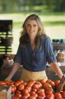 Woman standing at a farm stand stall — Stock Photo