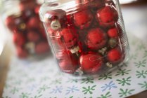 Christmas balls in glass jars on tabletop — Stock Photo