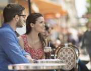 Couple sitting in seats at a pavement cafe — Stock Photo