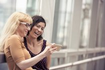 Zwei Frauen schauen auf ein Handy — Stockfoto