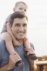 Homme portant son fils sur ses épaules . — Photo de stock