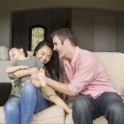Man and woman playing with young son. — Stock Photo