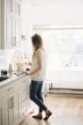Женщина стоит на кухне — стоковое фото