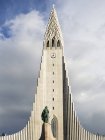 Alta torre de la iglesia moderna y estatua - foto de stock