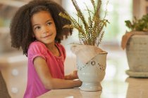 Дитина з горщиками і рослинами — стокове фото