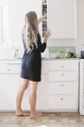 Woman standing barefoot in a kitchen — Stock Photo