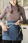 Woman tying the tape of an apron — стоковое фото