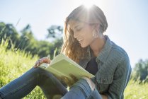 Woman  reading a book on meadow — Stock Photo