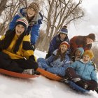 Enfants chevauchant sur des traîneaux sur la neige . — Photo de stock