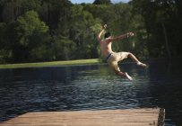 Menino pulando em uma piscina calma — Fotografia de Stock