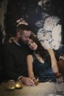 Пара, сидящая в низко освещенном баре — стоковое фото