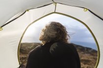 Человек, сидящий в укрытии палатки — стоковое фото