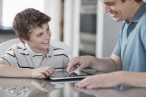Мужчина и мальчик с цифровым планшетом — стоковое фото