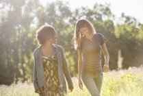 Zwei Frauen gehen durch ein Feld — Stockfoto